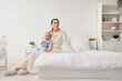 © Pixel-Shot - Young woman with her baby suffering from postnatal depression in bedroom