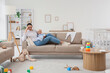 © Pixel-Shot - Young mother with her baby suffering from postnatal depression on sofa at home