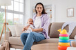 © Pixel-Shot - Young mother with her crying baby suffering from postnatal depression on sofa at home