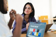 © Studio Marmellata - A smiling businesswoman listens intently to her male colleague during a collaborative meeting in a modern office. They are engaged in a productive discussion.