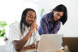 © Studio Marmellata - Diverse colleagues collaborate on a project in a bright office. The man smiles, looking at his laptop, while the woman leans in to review content. They are engaged in productive teamwork.