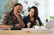 © Studio Marmellata - A diverse couple or colleagues are collaborating at a table in a bright office. The man smiles while the woman holds a pencil, focusing on documents. They are planning or working together.