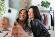 © Studio Marmellata - A diverse young couple takes a playful selfie with a smartphone. The man sticks out his tongue while the woman winks, sharing a fun moment together.
