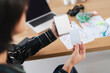 © Studio Marmellata - A person holds a portable instant photo printer and a blank photo print. A laptop and papers are on a wooden desk, suggesting a creative or memory-making activity.