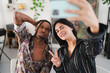 © Studio Marmellata - A young man and woman take a selfie together. The woman smiles and makes a peace sign while holding the phone. The man makes a funny face beside her. They are enjoying a moment.