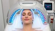 © SUPAPORN - facial reshaping A woman relaxes under a light therapy device for skin treatment in a modern salon.