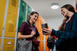 © Halfpoint - Teen students hanging out in school hallway by lockers.