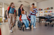 © Halfpoint - Teen students in school hallway, girl in wheelchair.