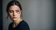 © Xenia - Woman victim of violence, depicting elimination of violence, stands with bruised face against a neutral background. Elimination of violence and domestic abuse are serious issues,