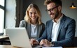 © guo - Professional business people, two happy business man and woman executives partners team working together checking corporate results standing in company office using laptop looking at camera. Portrait