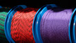 © Aleksandr Matveev - Multicolored industrial ropes for industrial mountaineering on reels hang on a stand in the market, industrial mountaineering concept background.