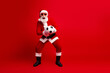 © deagreez - Santa Claus holding a soccer ball on a vibrant red background, showcasing holiday cheer and athletic spirit
