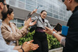 © qunica.com - Business people celebrating an achievement together outside, expressing optimism and joy by applauding.
