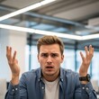 © ART.LAB.IA - Man with hands raised in confusion wearing a blue shirt and a watch in an office setting looking puzzled