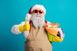 © deagreez - Festive santa with beige apron and yellow gloves holding cleaning supplies and spray bottles while giving a thumbs up