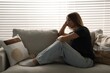 © New Africa - Depressed teenage girl on sofa at home