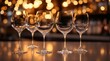 © Ksu - Five elegant wine glasses arranged on a reflective surface. Soft bokeh lights in the background create a warm atmosphere. Ideal for dining or celebration themes.