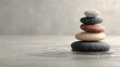 © illustratica - Stack of zen stones balancing on water surface with ripples