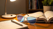 © Olga - Blue light glasses pair placed beside study materials on wooden table