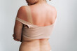 © Ilona - Woman wearing an off-shoulder beige top, back view with tan line and relaxed pose