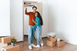 © Prostock-studio - A young couple smiles happily in their new apartment, holding keys in celebration. They are surrounded by moving boxes and are dressed casually, embodying excitement about this new chapter.