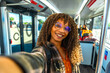 © unai - Young woman smiling taking selfie in bus
