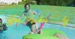 © vectorfusionart - Aiming woman squirting pink water gun in home pool, seated in bright green donut wearing swimsuit