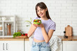 © Pixel-Shot - Young woman with fresh vegetable salad in  kitchen