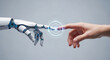 © abu - Close-up of a human hand touching a robotic hand on a gray backdrop with a glowing digital interface, illustrating futuristic interaction and artificial intelligence concepts.