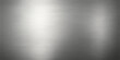 © Alpha Designs - A brushed stainless steel metal texture background or plate with a shiny metallic silver surface and industrial light reflection