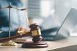© Garun Studios - law, legal, justice, court, attorney, A wooden gavel and justice scale placed on a desk with a laptop in the background, symbolizing law, legal decisions, court judgement, and attorney services.
