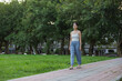 © leungchopan - Woman walking outdoors in green park scenery