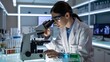 © MstTasmiya - Scientist examining samples through microscope in high-tech laboratory, wearing protective eyewear, symbolizing scientific research, biotechnology, medical innovation, and laboratory analysis