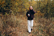 © Westend61 - Woman walking in autumn forest with coffee practicing mindfulness outdoors