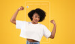 © Prostock-studio - A woman stands confidently in front of a bright yellow background, flexing her muscles with a smile. She exudes empowerment while surrounded by a playful collage design, emphasizing her strength.