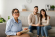 © Prostock-studio - A happy arab female marital counselor smiles confidently in her office after an effective therapy session with a middle eastern couple. Trust and communication are evident in the room.