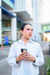 © Ranta Images - Portrait of a young Thai transgender business person in city texting with phone