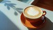 © 亚磊 崔 - crema. A hot latte on a cafe table, bathed in morning light with warm tones. bar promotions, beverage menus, designed for food & beverage menus and cafe branding, used by food bloggers.