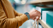 © perfectlab - Person wearing smartwatch with blue strap reaching for a box on a shelf in a retail or storage environment