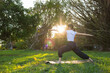 © leungchopan - Woman practicing yoga in park warrior two pose