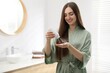 © New Africa - Woman using talcum powder as dry shampoo at home