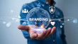 © Rakib Rakib - Hand holding a global branding hologram with team security and customer loyalty icons shining brightly