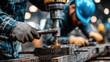© Eduards V. - Industrial worker using a drilling machine in a metal fabrication workshop