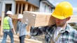© Eduards V. - Construction workers carrying wood on a building site