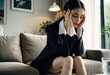 © Aliaksandr Barouski - Professional woman in a blazer sits distressed on a sofa, holding her temples.