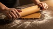 © Alex - Close up of hands rolling out dough on a floured wooden surface