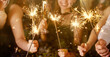 © New Africa - Happy New Year 2026 greeting card. Friends with sparklers and wine glasses indoors, closeup
