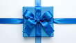 © Uwantha - Top View of a Bright Blue Gift Box Wrapped with a Wide Satin Ribbon and Bow on a Simple White Background - Present for Birthday, Holiday, or Special Event