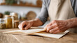 © sabyna75 - Senior chef flipping through cookbook in rustic kitchen for recipe inspiration