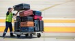 © photoplotnikov - Airport baggage handler stacking luggage on cart at runway